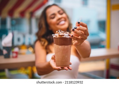 Young afro woman holding a milkshake in her hand. Woman with a milkshake - Shutterstock ID 2118123932