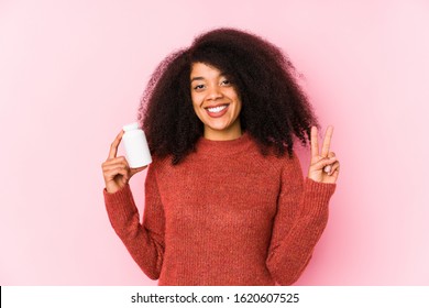 Young Afro Woman Holding A Vitamins Isolated Young Afro Woman Holding A Vitaminsshowing Number Two With Fingers.