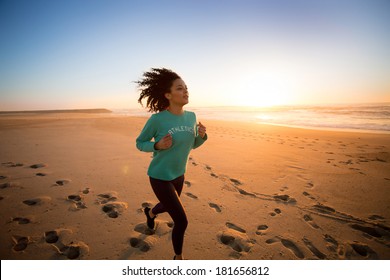 Young afro woman running on the beach