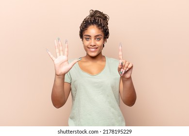 Young Afro Woman Smiling And Looking Friendly, Showing Number Six Or Sixth With Hand Forward, Counting Down