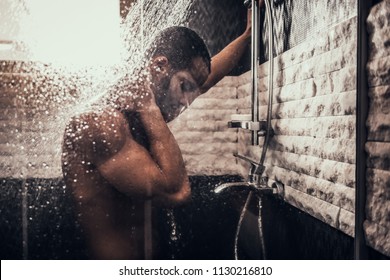 Young Afro-American Man Taking Shower in Bathroom at Morning. Standing Man with Bare Torso in Bathroom. Personal Morning Routine. Fresh at Morning. Guy near Mirror. Hygiene at Morning Concept.