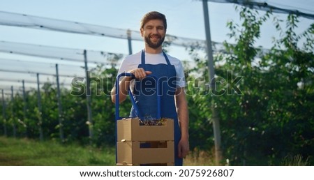 Foto Bild junger Mann Agronom, der einen Kürbis hält.