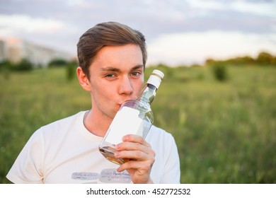 Young Alcoholic  Man, Kissing Empty Bottle Of Brandy, Staying Alone Outdoors