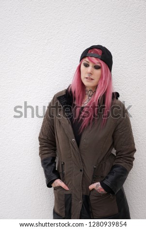 young alternative woman with pink hair looking down                            