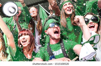 Юные болельщики-любители болеют конфетти, наблюдая за матчем местного футбольного кубка на стадионе - друзья, люди, одетые в зеленые футболки, веселятся на финале чемпионата мира по спорту