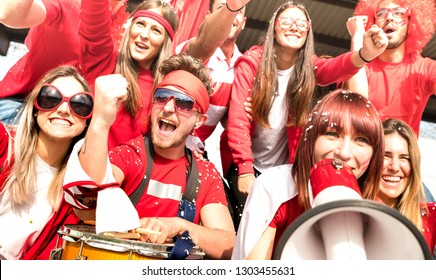 Young Amateur Football Supporter Fans Cheering With Flags Watching Local Soccer Cup Match At Stadium - Friends People Group With Red T Shirts Having Excited Fun On Sport World Championship Concept