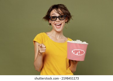 Young Amazed Surprised Fun Cheerful Woman In 3d Glasses Watch Movie Film Hold Bucket Of Popcorn In Cinema Point Index Finger Camera On You Isolated On Plain Olive Green Khakibackground Studio Portrait