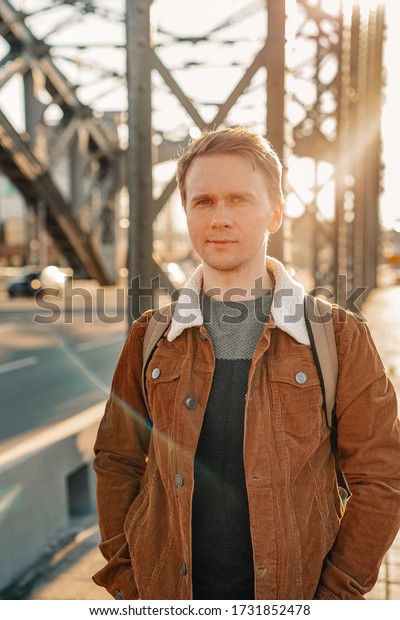 A young ambitious
business man walks along the streets, a metal bridge in a Sunny
beautiful sunset