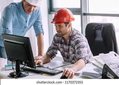 Young Ambitious Constructor With His Partner Are Doing The Model Of Building On The Computer. Engineer Is Good At Computers