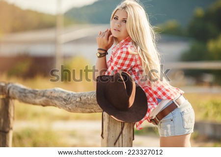 Young american cowgirl woman portrait outdoors. Beautiful natural woman saying hello looking at camera.  girl in her twenties outdoor in nature.