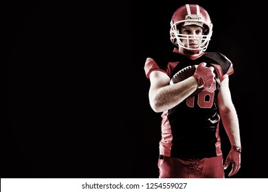 Young American football player in helmet holding rugby ball - Powered by Shutterstock