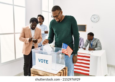 Young American Voter Man Smiling Happy Putting Vote In Voting Box At Electoral Center.