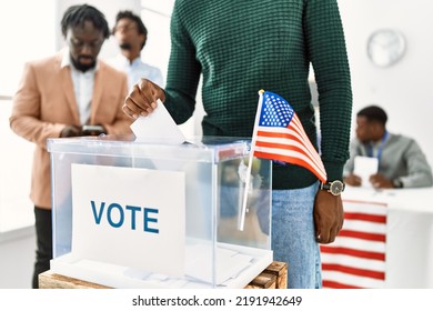 Young American Voter Man Smiling Happy Putting Vote In Voting Box At Electoral Center.