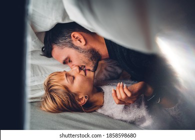 Young Amorous Couple Kissing Under Blanket - Boyfriend And Girlfriend Cuddling On The Bed At Home