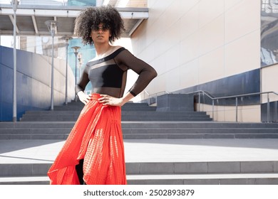 Young androgynous fashion model posing with hands on hips on stairs in an urban setting - Powered by Shutterstock