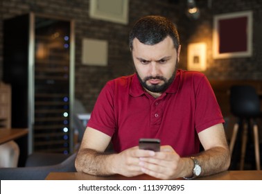 Young Angry Man Typing On Mobile Phone