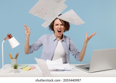 Young Angry Sad Director Employee Business Woman In Casual Shirt Sit Work At White Office Desk With Pc Laptop Throwing Up Paper Account Documents Scream Shout Isolated On Pastel Blue Background Studio