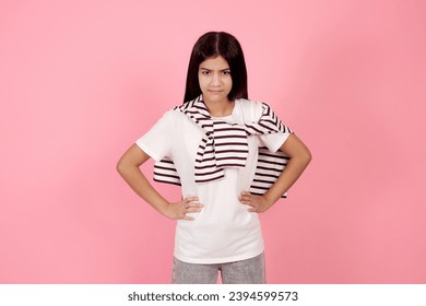 Young angry teenage girl on pink background in studio. - Shutterstock ID 2394599573
