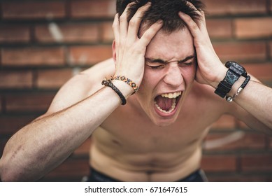Young angry teenager screaming with pain and frustration