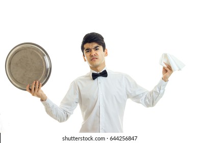 The Young Angry Waiter In A White Shirt Holding A Tray Of Crockery And Napkin
