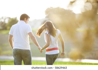 Young Anonymous Couple Taking A Walk On Nature