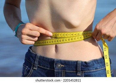 Young Anorexic Girl Measures With The Tape Measure Her Tight Waistline