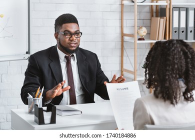 Young applicant answering HR manager's questions during job interview at office