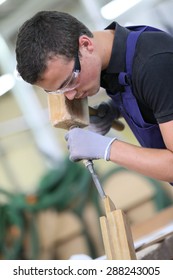 Young Apprentice In Carpentry Working Piece Of Wood