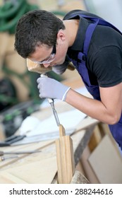 Young Apprentice In Carpentry Working Piece Of Wood