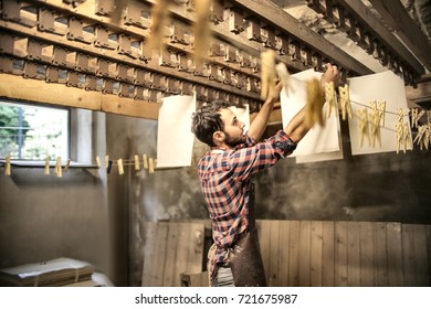 Young apprentice hanging handmade paper
