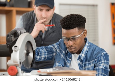 young apprentice learning to use circular saw