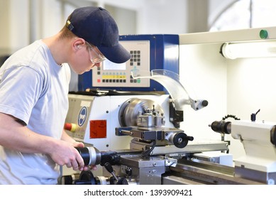 Young Apprentice In Vocational Training Working On A Turning Machine In The Industry 