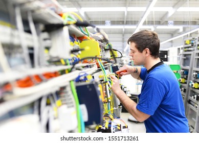 Young Apprentice Worker In An Industrial Company Assembling Electronic Components In The Mechanical Engineering Of A Modern Factory 