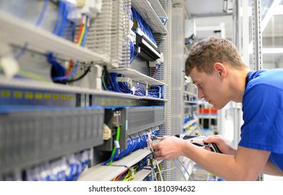 Young Apprentice Worker In An Industrial Company Assembling Electronic Components In The Mechanical Engineering Of A Modern Factory 