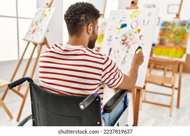 Young arab disabled artist man back view drawing sitting wheelchair at art studio 