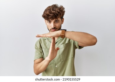 Young Arab Doctor Man Standing Over Isolated Background Doing Time Out Gesture With Hands, Frustrated And Serious Face 