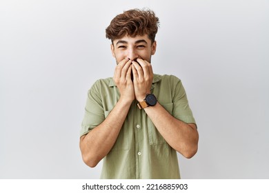 Young Arab Doctor Man Standing Over Isolated Background Laughing And Embarrassed Giggle Covering Mouth With Hands, Gossip And Scandal Concept 