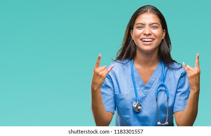 Young Arab Doctor Surgeon Woman Over Isolated Background Shouting With Crazy Expression Doing Rock Symbol With Hands Up. Music Star. Heavy Concept.