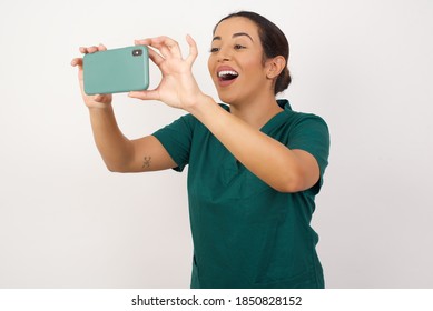 Young Arab Doctor Surgeon Woman Over Isolated White Background Taking A Selfie To Post It On Social Media Or Having A Video Call With Friends.