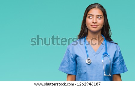 Young arab doctor surgeon woman over isolated background smiling looking side and staring away thinking.