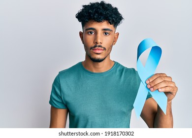 Young Arab Handsome Man Holding Blue Ribbon Thinking Attitude And Sober Expression Looking Self Confident 
