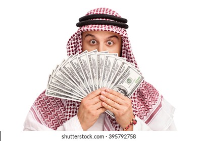 Young Arab hiding his face behind a stack of money isolated on white background