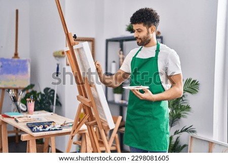 Young arab man artist smiling confident drawing at art studio