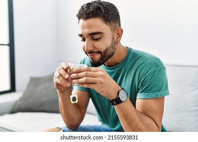 Young Arab Man Drinking Tea Sitting On Sofa At Home