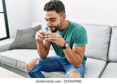 Young Arab Man Drinking Tea Sitting On Sofa At Home