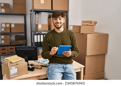 Young arab man ecommerce business worker using touchpad at office