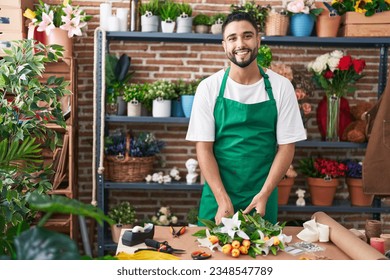 Young arab man florist make bouquet of flowers at flower shop - Powered by Shutterstock