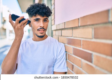 Young Arab Man Listening Audio Message Using Smartphone At City