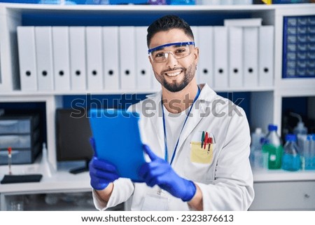 Young arab man scientist using touchpad working at laboratory