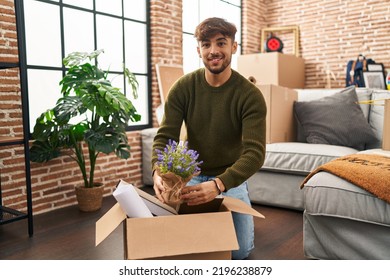 Young Arab Man Smiling Confident Unboxing Lavander Plant At New Home